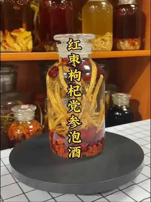 广口玻璃罐中正在浸泡的红参酒，酒液清澈，红参饱满，旁边配有枸杞和红枣。_1