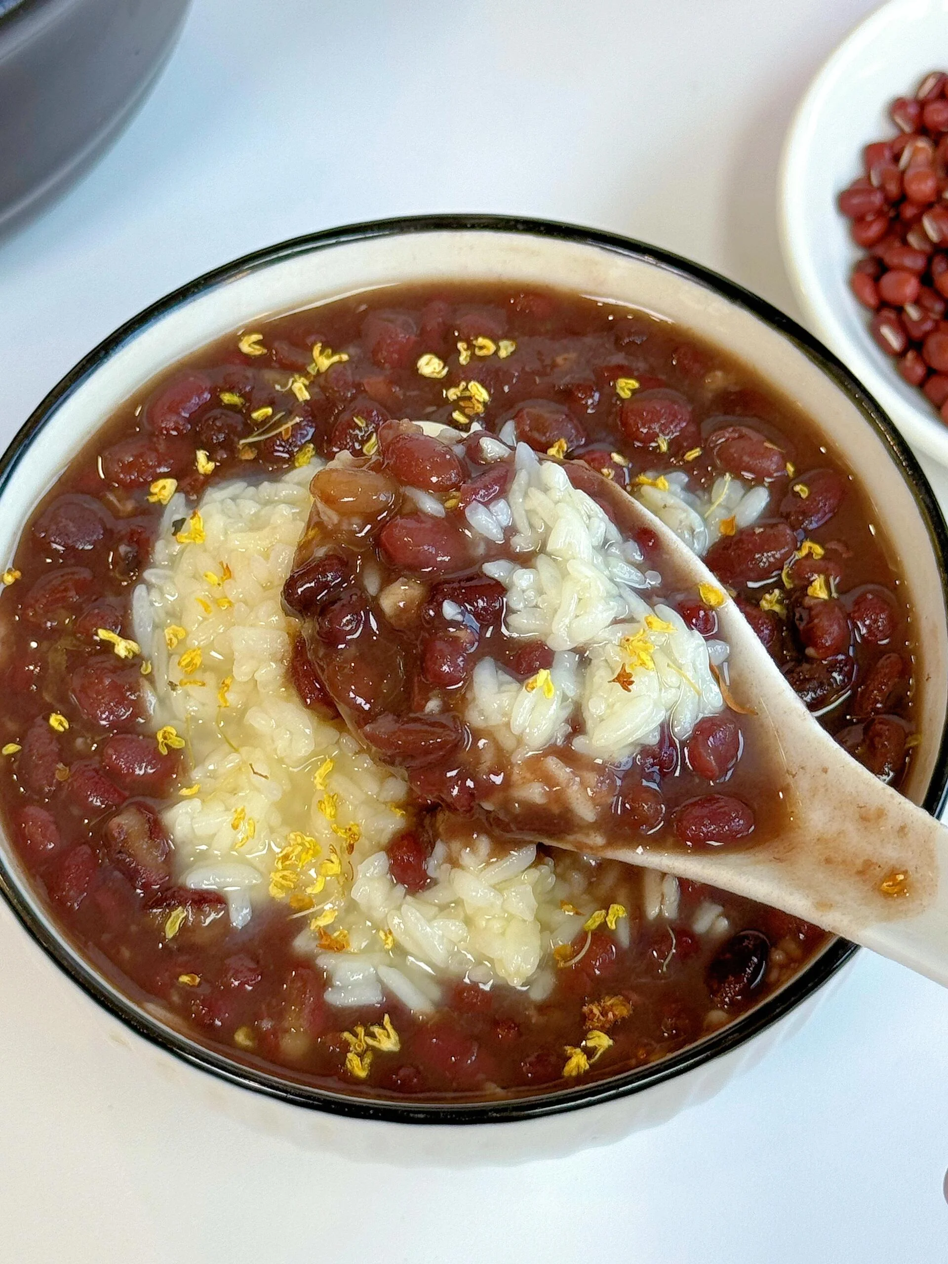 制作红豆甜酒酿前的准备工作：蒸好的糯米饭和煮好的红豆分别盛放在容器中，以及必备的甜酒曲。_1