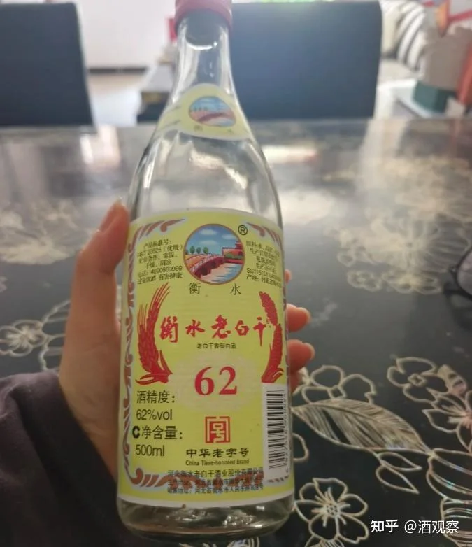 超市货架上，一瓶白酒的背面配料表特写镜头，配料仅为粮食和水，旁边是一杯清澈的酒液。_1