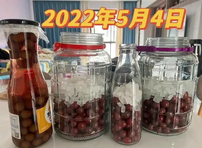 家庭酿酒师用玻璃罐酿造李子酒的实拍过程，展示了新鲜的果肉和清澈的酒液。_1