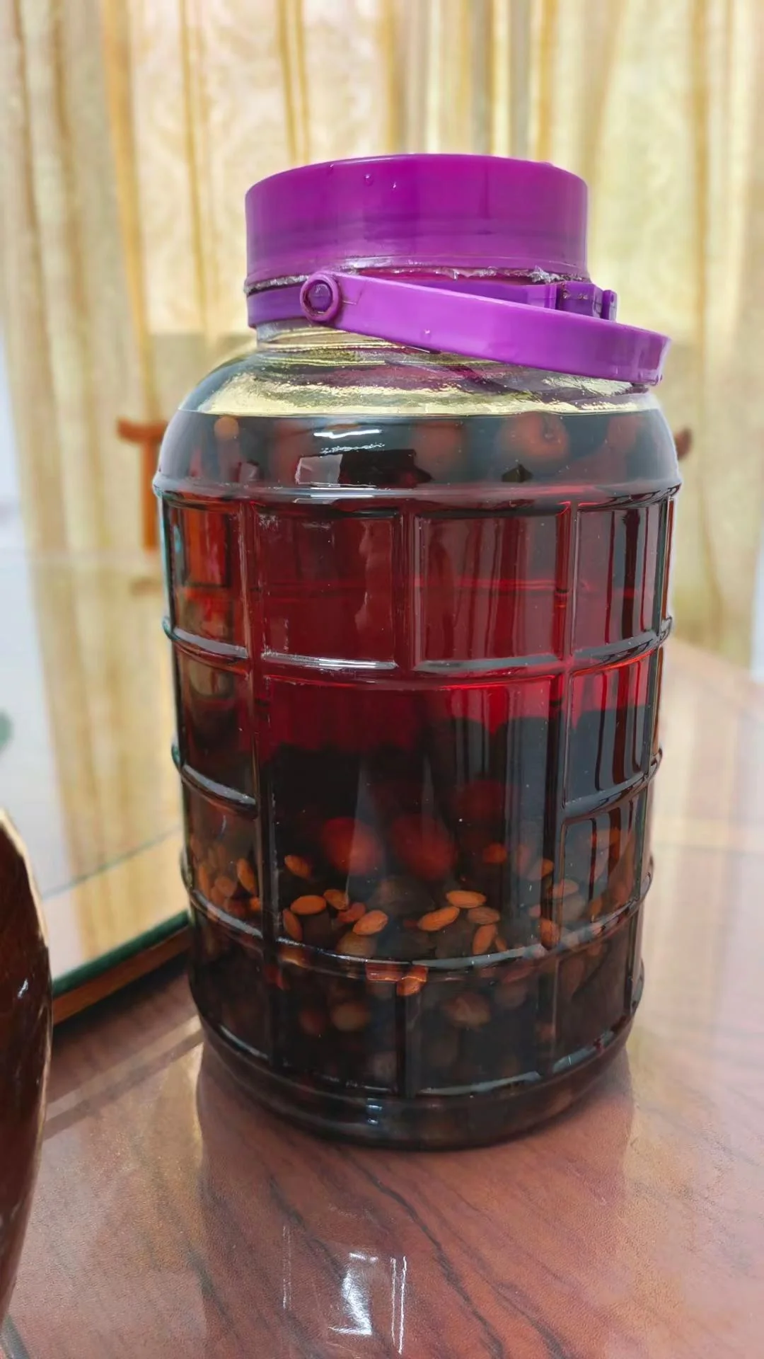 家庭自酿甜竹花酒实拍图：玻璃瓶中清澈酒液浸泡着甜竹花和枸杞_1