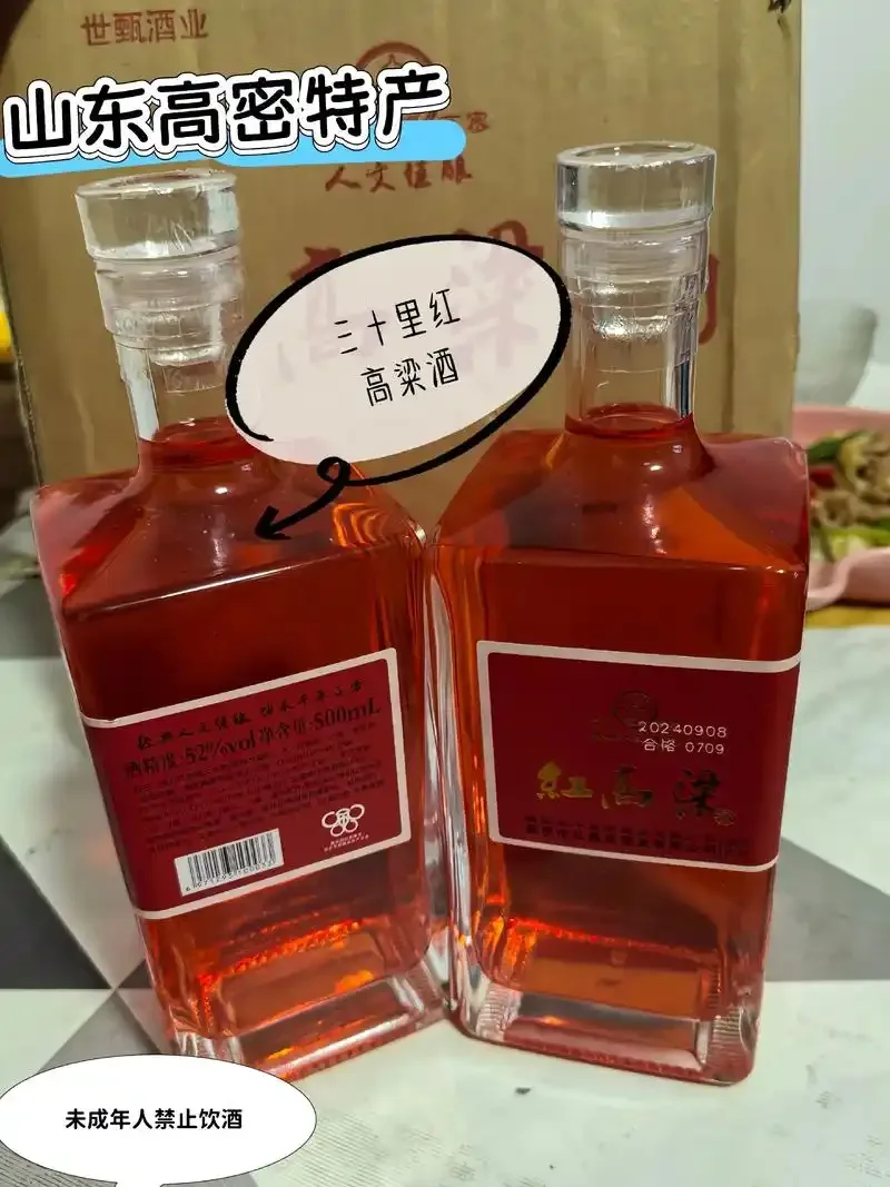 一瓶大地红高粱酒与红润的高粱米摆放在木质桌面上的特写照片_1