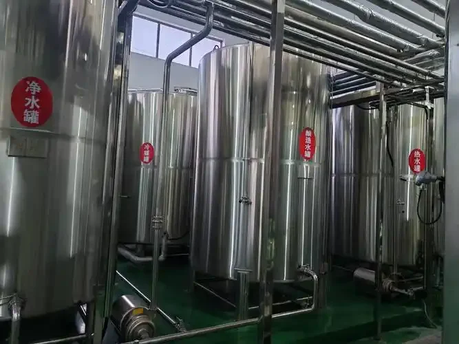 一套小型不锈钢精酿啤酒设备在工作室中的俯拍图，周围摆放着麦芽、酒花和酿酒工具，展现专业家酿或小型商酿场景。_1