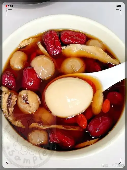 红枣桂圆枸杞当归泡酒成品特写：透明玻璃罐中琥珀色酒液，清晰可见饱满红枣、光亮桂圆、鲜艳枸杞和当归片，呈现传统养生泡酒的温润质感。_1
