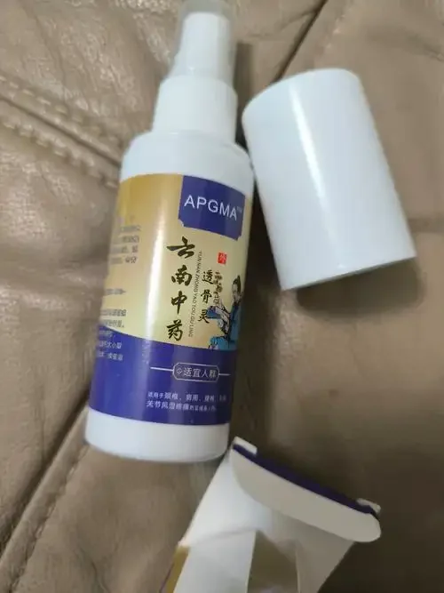 骨关节炎药酒泡制过程展示：透明酒坛中浸泡着当归、川芎等多种中药材，酒液呈琥珀色，旁边摆放着药材和古籍。_1