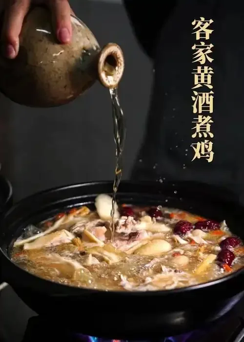 一锅刚出锅的黄酒煮鸡，汤色金黄，鸡肉鲜嫩，热气缭绕，非常诱人。_1