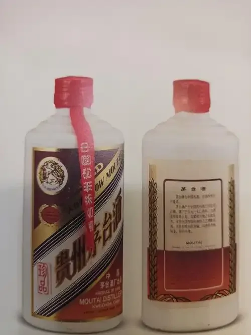 资深酿酒师在检查陈年白酒：放大镜聚焦于老酒瓶的瓶盖与泛黄标签细节，旁边放着一杯琥珀色的酒液。_1