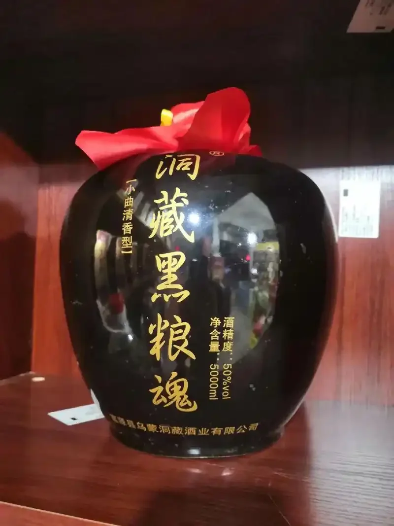 资深酿酒师在天然山洞中检查洞藏黑粮魂酒的陶坛陈化情况_1