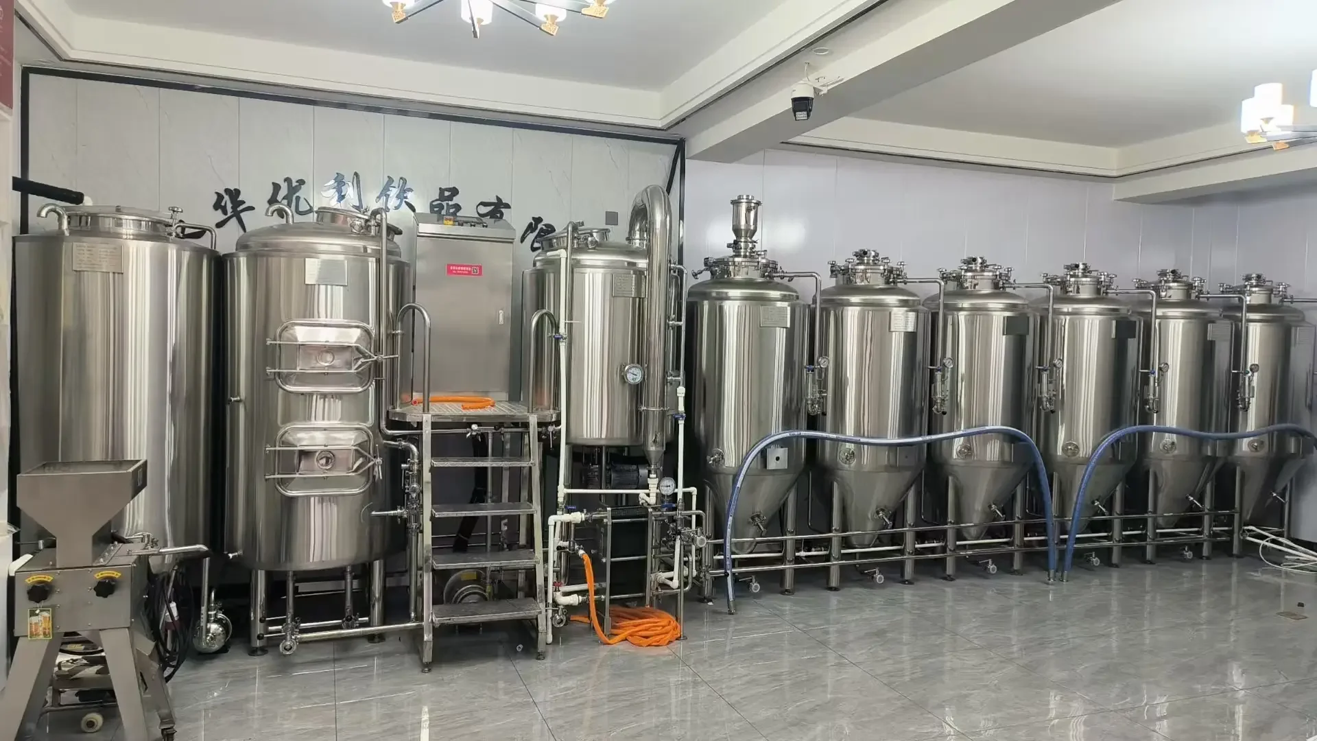 家庭自酿啤酒设备套装在厨房台面上的展示，包含煮沸锅、发酵罐和常用工具。_1