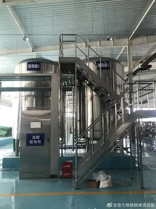 酿酒师在车间操作不锈钢鲜啤酒生产设备的场景_1