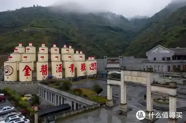 茅台镇传统酒厂内部实景：一排排陶坛在柔和的光线下，工人正在细心照料，展现了酱香酒酿造的真实场景。_1