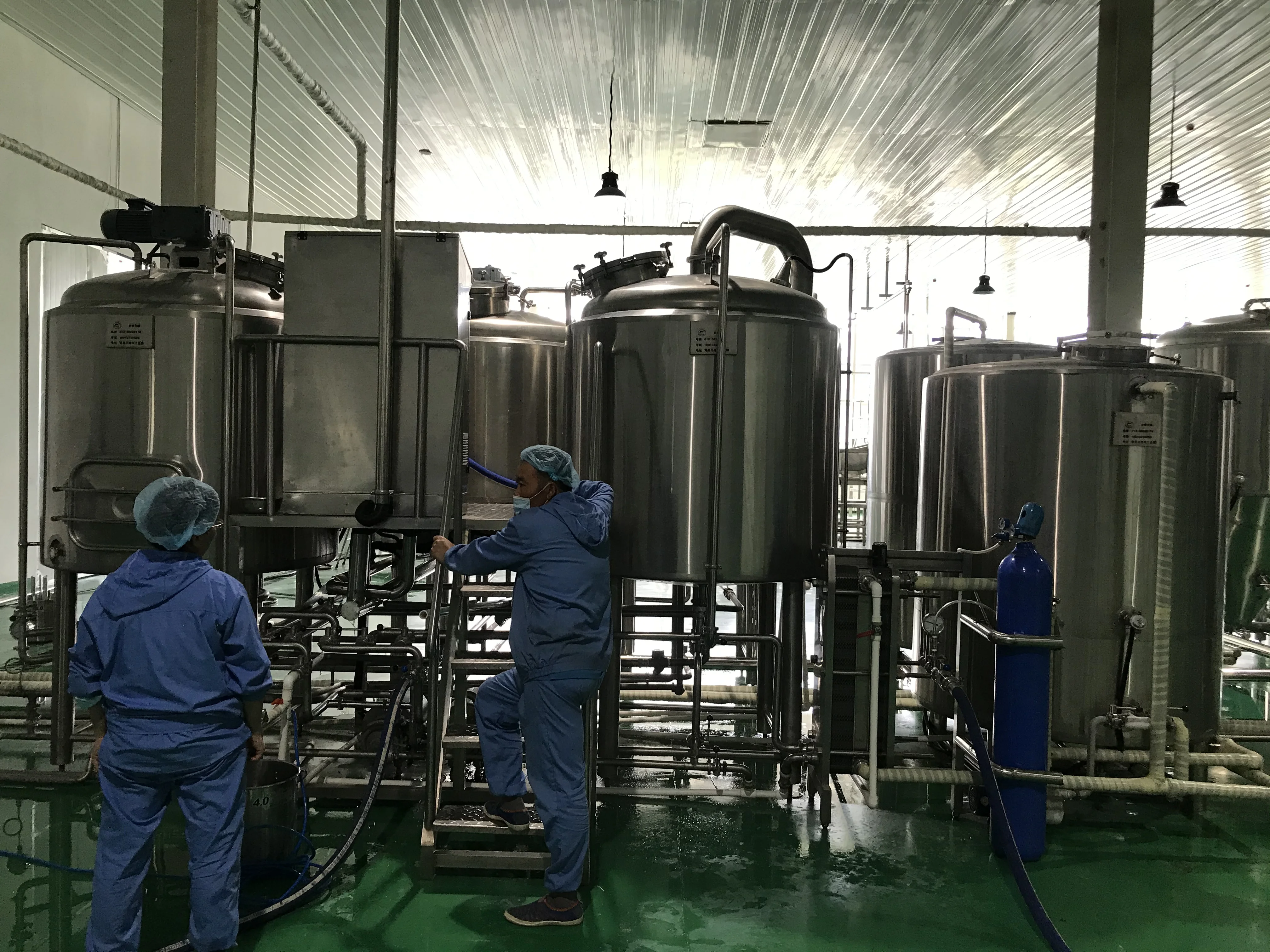 一套完整的家庭或小型精酿啤酒酿造设备，包括糖化煮沸锅和锥形发酵罐，展示在整洁的工作室中_1