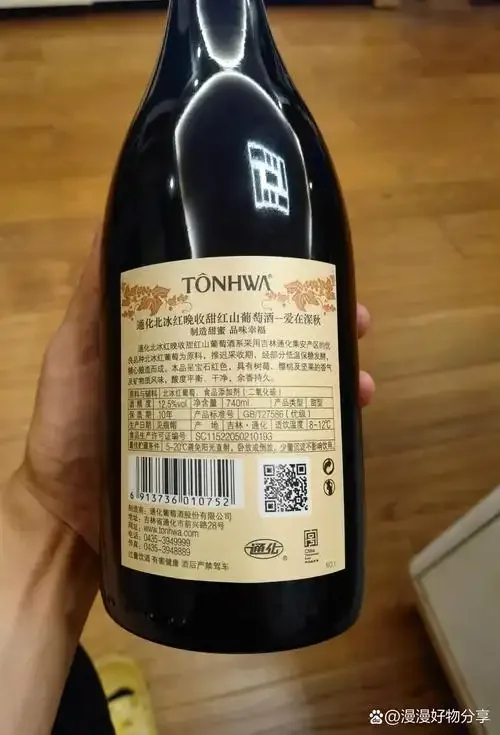 一瓶红葡萄酒及其配料表特写，用放大镜观察细节，背景有酒杯和葡萄，用于教学如何鉴别真酒。_1