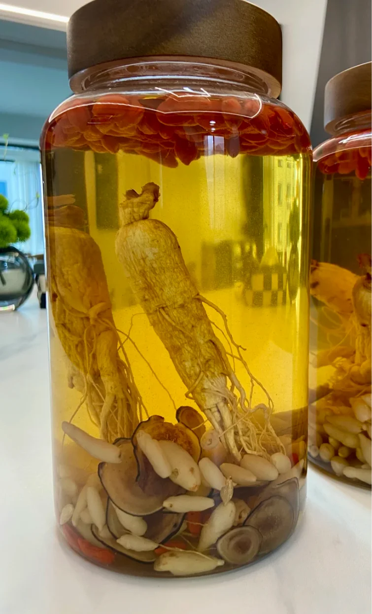 人参泡酒实物图，展示玻璃罐中人参、枸杞与白酒的黄金比例状态_1