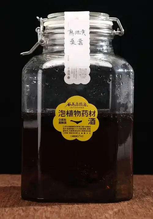 家庭泡制药酒的玻璃罐特写，罐内清澈酒液中浸泡着枸杞、人参片、当归等常见中药材，光线柔和，氛围温馨。_1