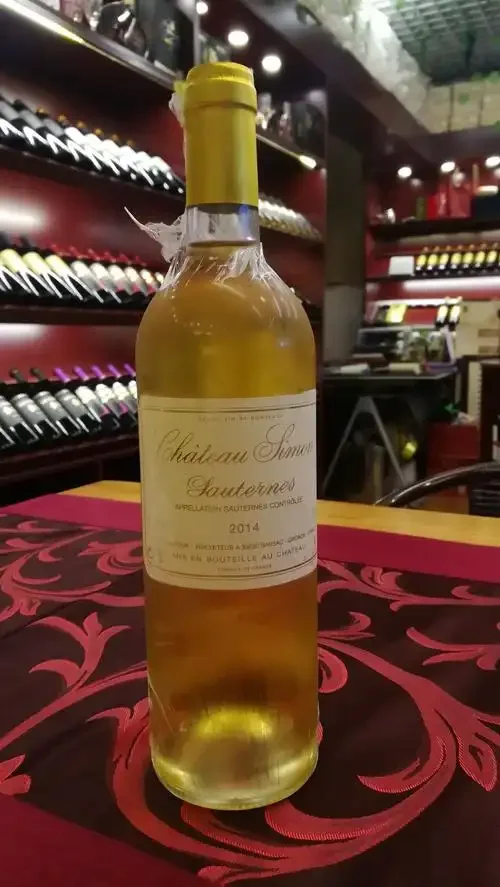 酿酒师正在品尝从橡木桶中取出的偏甜白葡萄酒，旁边有葡萄和测量工具_1