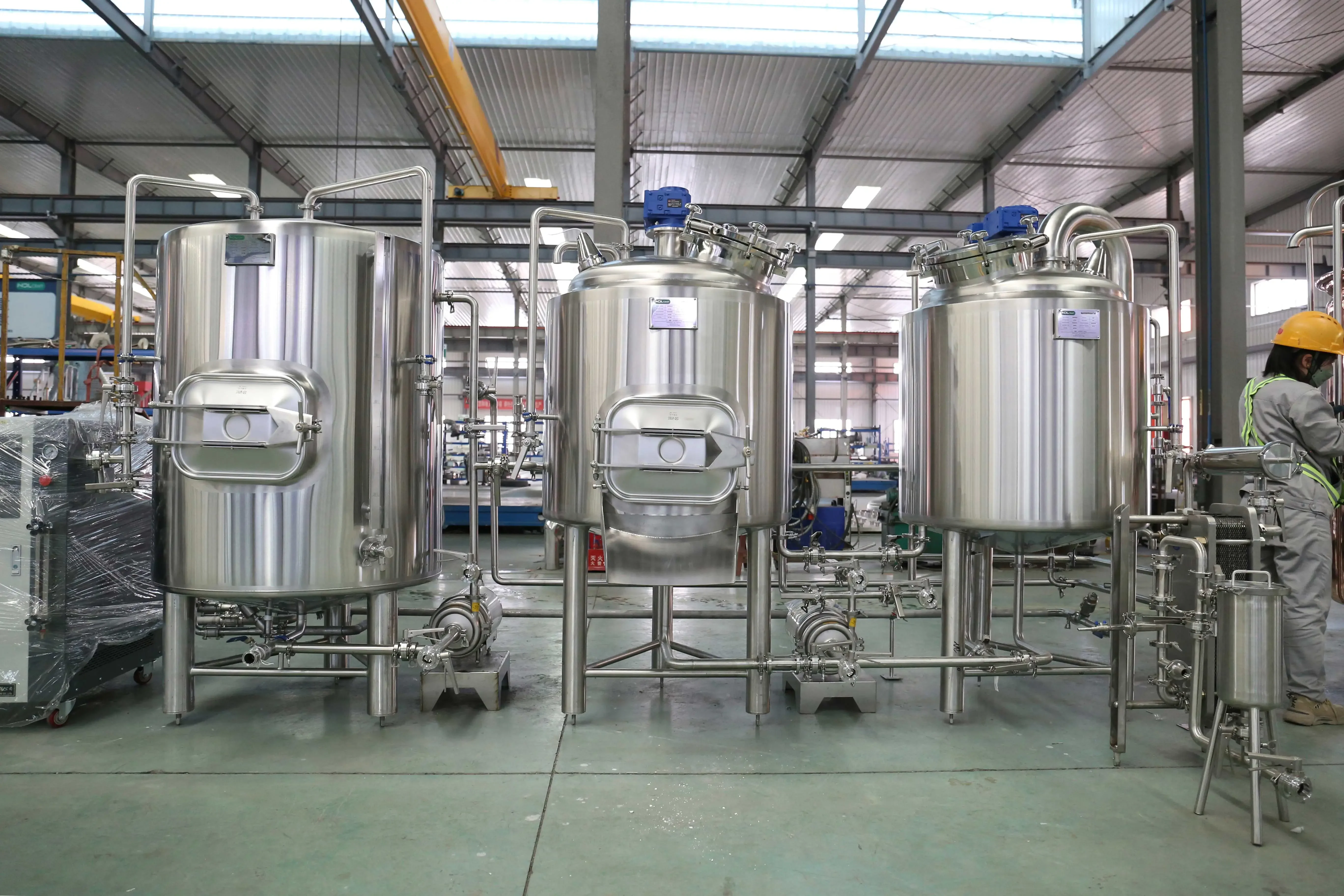 德国啤酒设备操作现场：酿酒师正在检查不锈钢糖化煮沸罐的仪表和阀门。_1