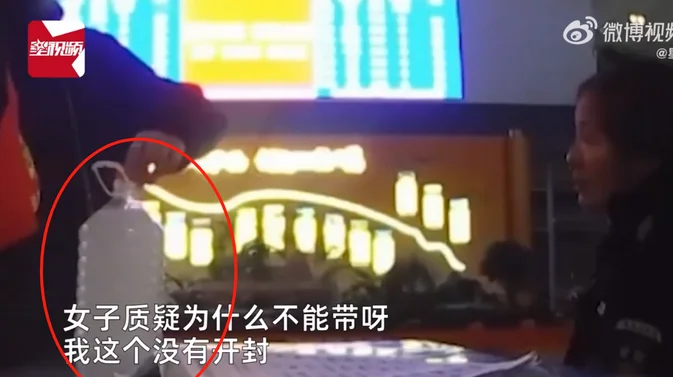 将瓶装白酒安全打包入行李箱的特写过程，展示如何用缓冲材料保护酒瓶。_1