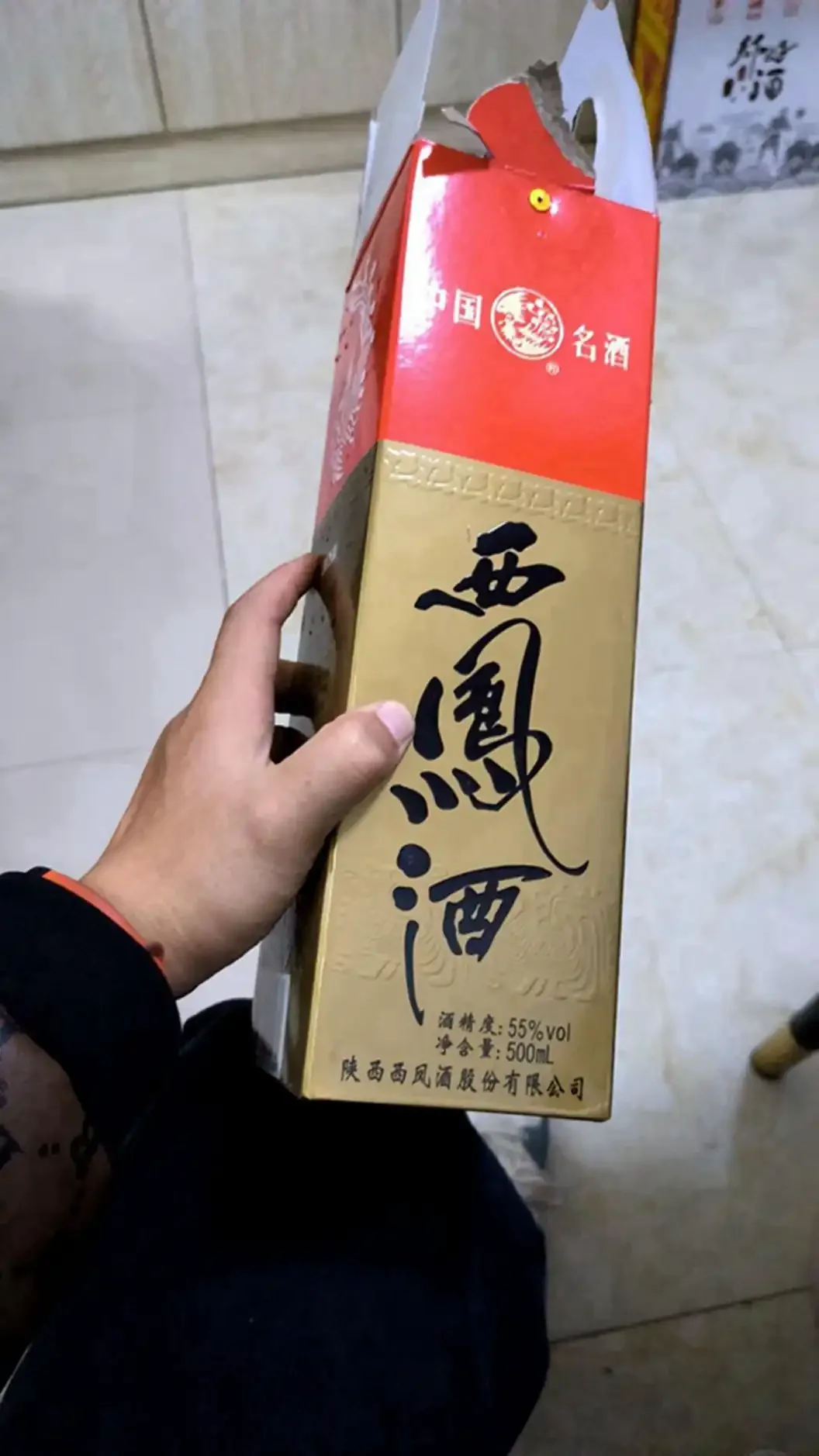 资深酿酒师在传统酿酒坊中，手持一杯纯粮白酒进行讲解和展示_1