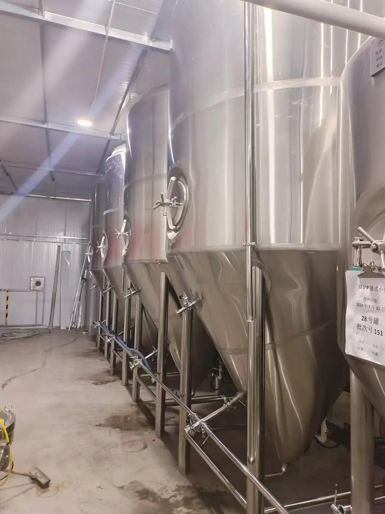 家酿啤酒爱好者正在使用一套小型啤酒酿造设备进行操作，旁边摆放着麦芽和啤酒花原料。_1