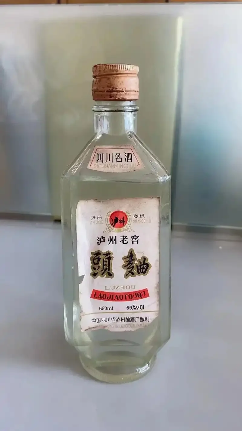 传统白酒蒸馏过程中，从蒸馏管口接取第一滴酒头液体的特写镜头_1