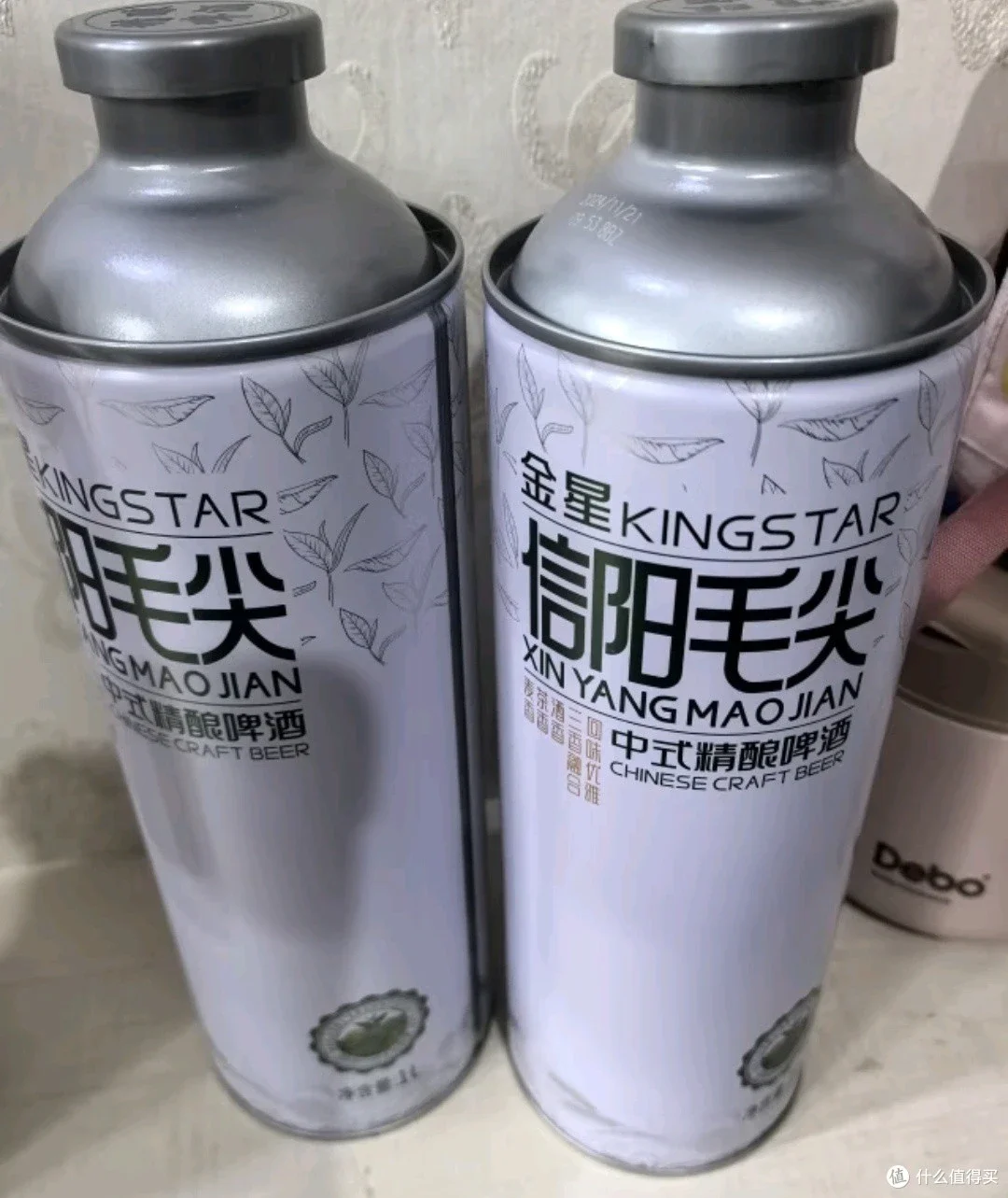 一杯自酿的金星茉莉花茶精酿啤酒特写，泡沫上点缀着茉莉花，旁边是酿造原料和发酵罐。_1