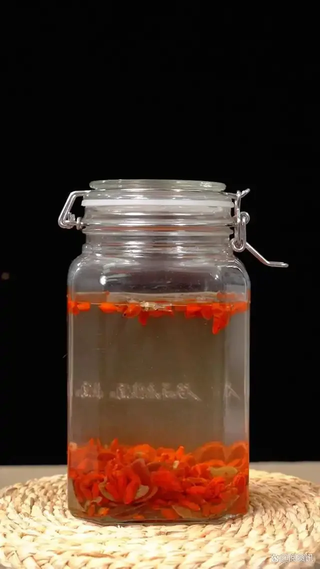 鹿茸黄芪泡酒成品展示：透明玻璃瓶中琥珀色酒液浸泡着鹿茸片和黄芪片。_1