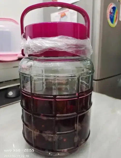 家庭自酿杨梅酒过程展示：透明玻璃罐中浸泡着新鲜杨梅与冰糖，酒液呈诱人的琥珀色。_1