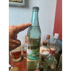 一瓶经典的江西97年陈酿高粱酒与酒杯、高粱粒、陶坛静置于古朴木桌上_1