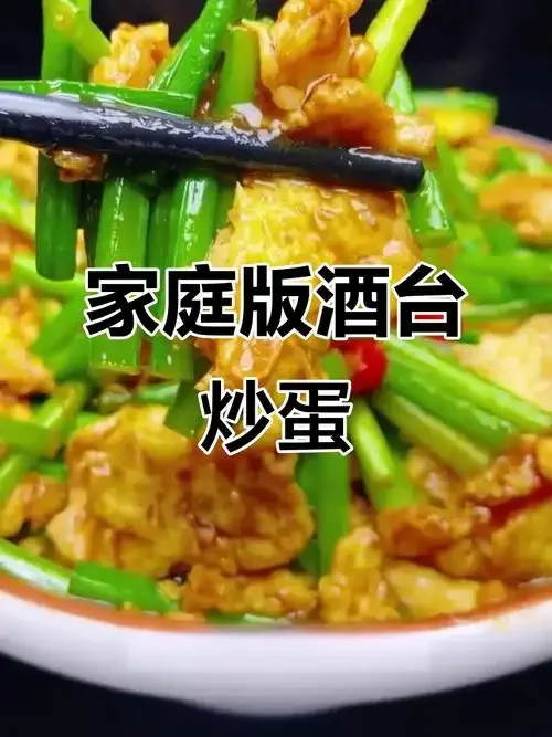 一盘用纯粮白酒炒制的金黄蓬松鸡蛋，旁边配有一个小酒盅，背景是传统的酿酒器具。_1