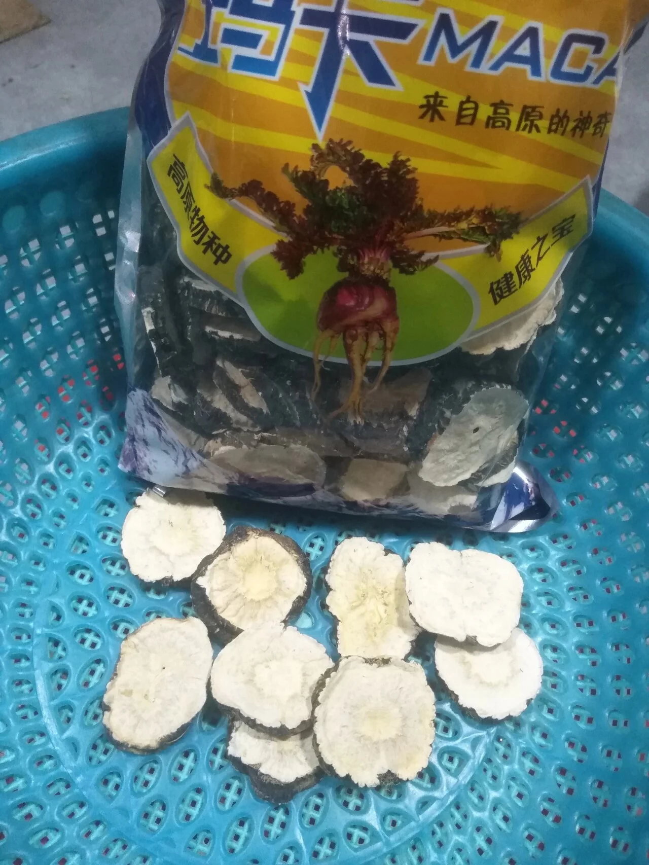 一瓶清澈的玛卡泡酒与干玛卡片在木桌上，背景为家庭酒柜，光线温暖自然。_1