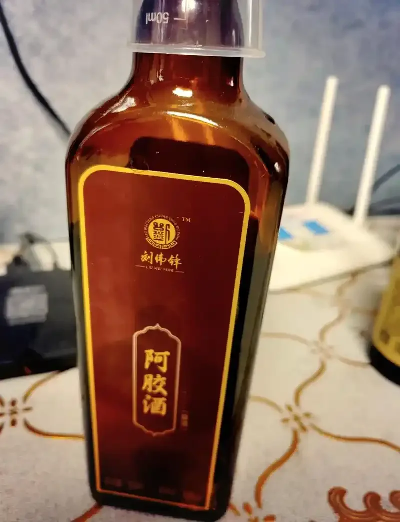 透明玻璃罐中正在浸泡的补气血药酒，可见枸杞、黄芪、当归等药材，色泽温润_1