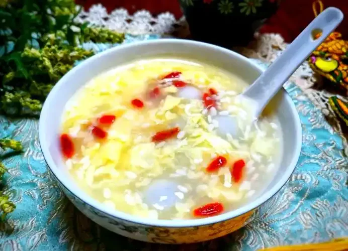 一碗煮好的甜酒汤圆，汤汁清澈，汤圆饱满，点缀枸杞和桂花，热气腾腾。_1