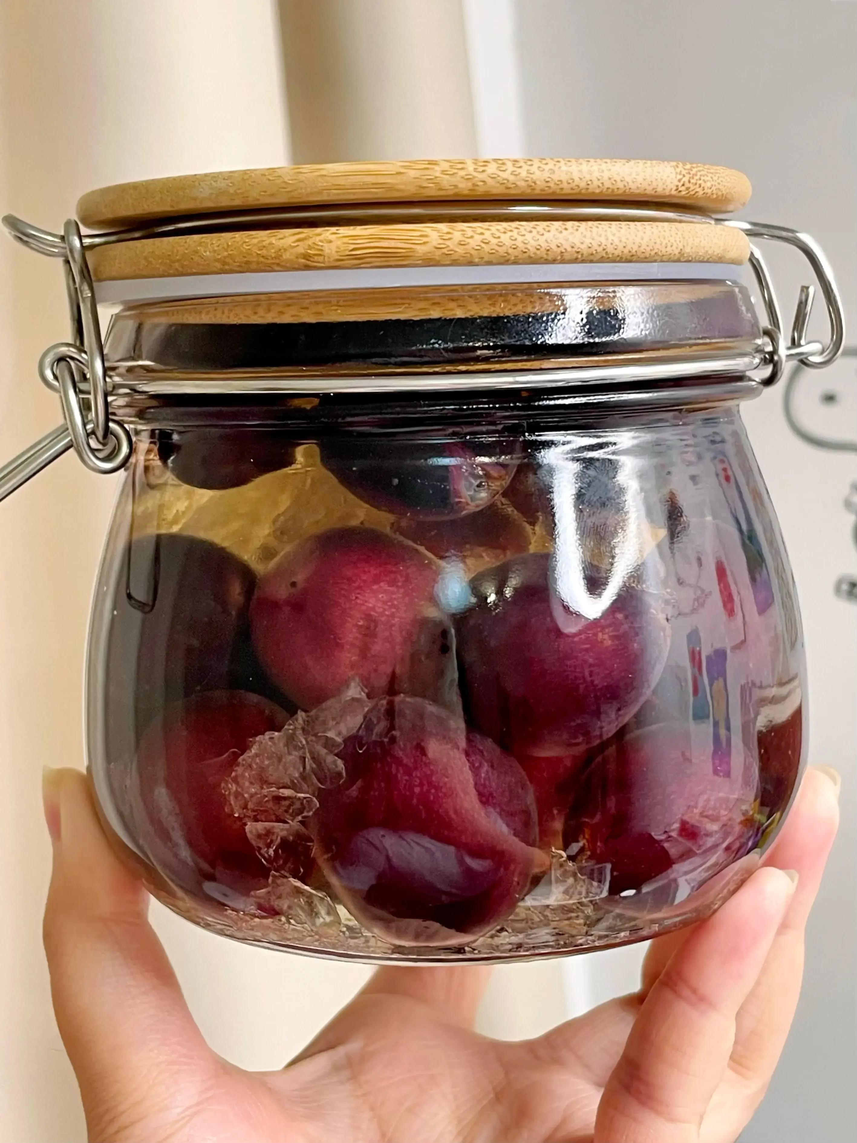 透明玻璃罐中浸泡着人参、枸杞的养生药酒，酒液清澈呈琥珀色，旁边散落着红枣和当归。_1