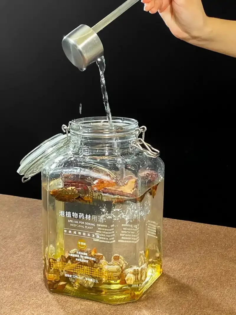 家庭自制丹参泡酒特写：透明玻璃罐中琥珀色酒液与红色丹参切片_1