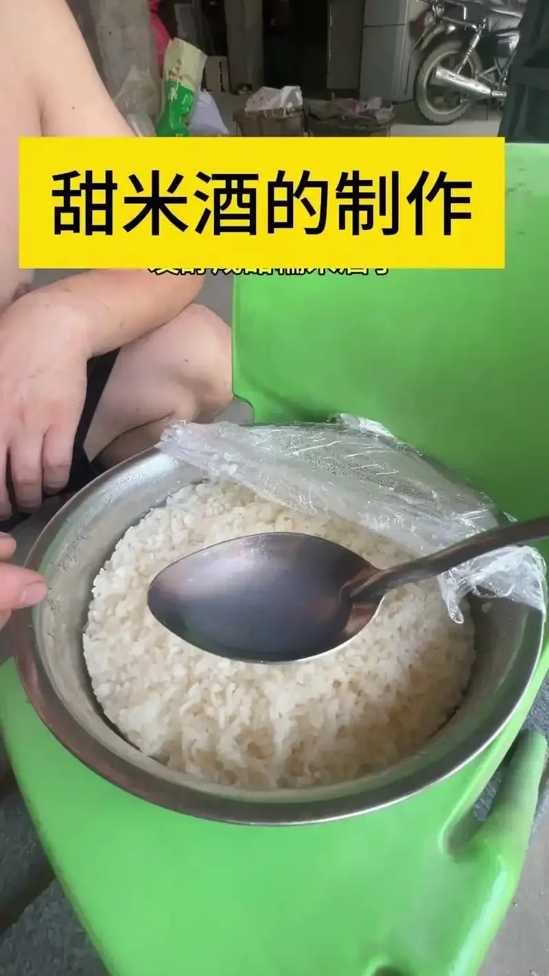 一碗刚酿好的家庭自制甜酒酿，米粒饱满，酒汁清澈，旁边配有酒曲和木勺。_1