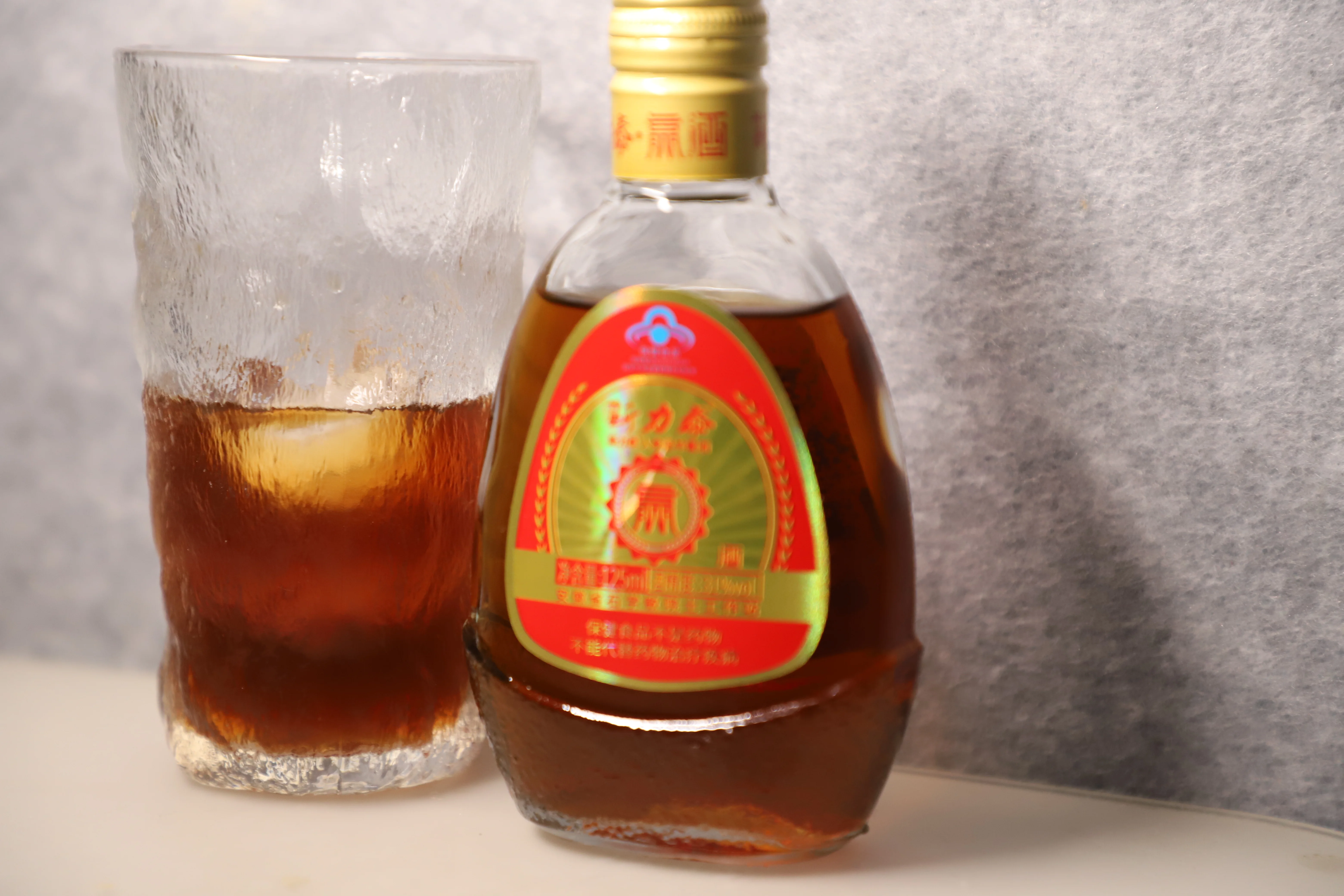 精选鹿茸、人参、枸杞等中药材与玻璃泡酒瓶摆放在木质工作台上，准备制作传统养生药酒。_1