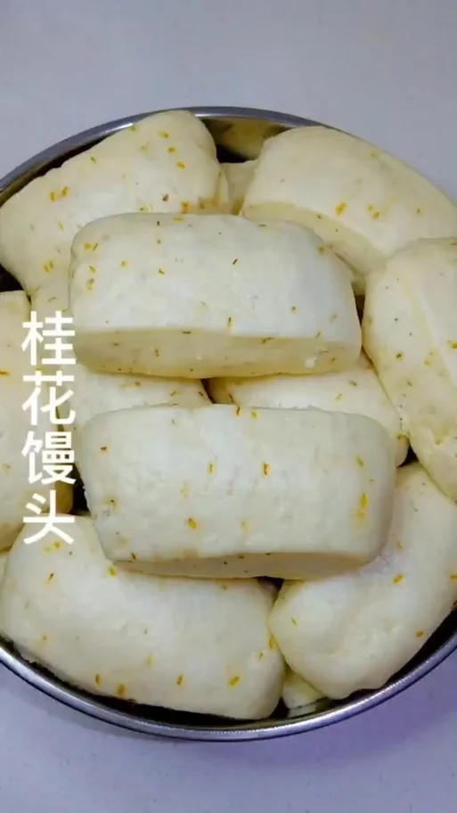 一笼热气腾腾、洁白松软的桂花酒酿馒头，表面能看到金黄的桂花碎，散发着诱人的香气。_1