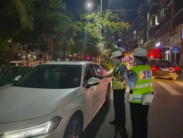 交警对驾驶员进行呼气式酒精检测现场特写，展示酒驾检测的实际操作过程_1