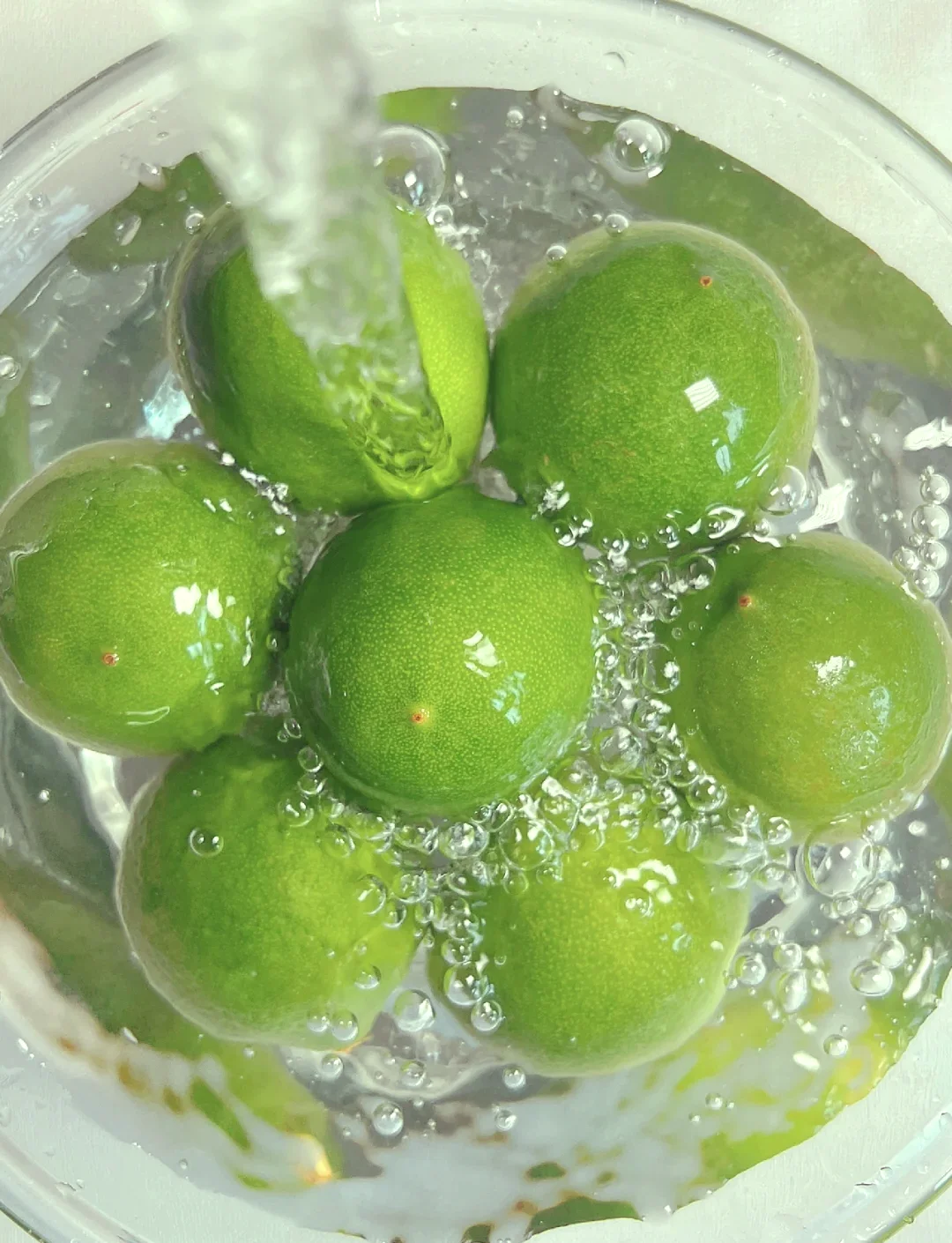 一瓶自制青柠檬酒与新鲜青柠檬、冰糖和泡酒工具摆放在一起的温馨场景_1