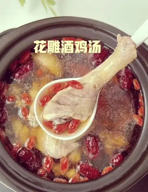 广东白酒煲鸡汤成品特写：金黄汤汁在砂锅中翻滚，配料清晰可见，旁边配以广东米酒。_1