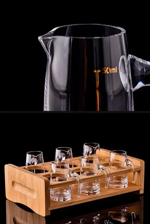 木质桌面上，一个装满白酒的透明玻璃分酒器与两个小酒杯的特写，展示家常饮酒的常见容量与场景。_1