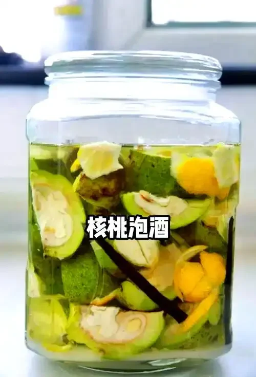 浸泡在琥珀色酒液中的青皮嫩核桃特写，展示自制嫩核桃酒的直观状态。_1