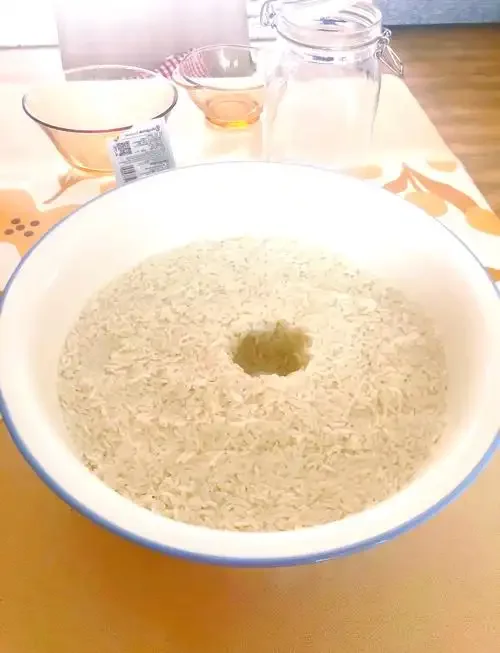 正在拌入酒曲的江米饭特写，展示家庭制作江米酒的关键步骤_1