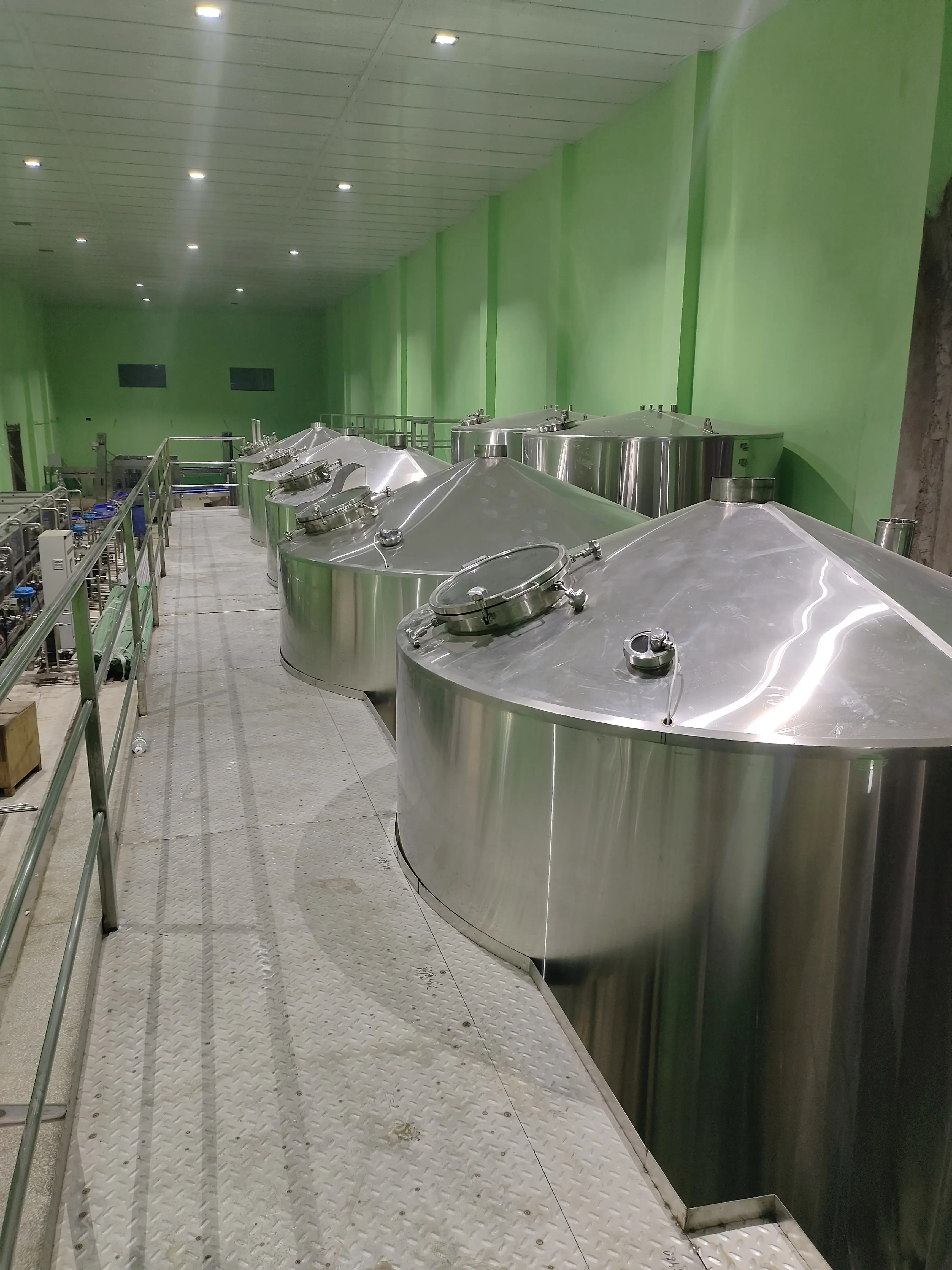 精酿啤酒工坊内景，展示不锈钢发酵罐与温控系统等专业酿造设备_1