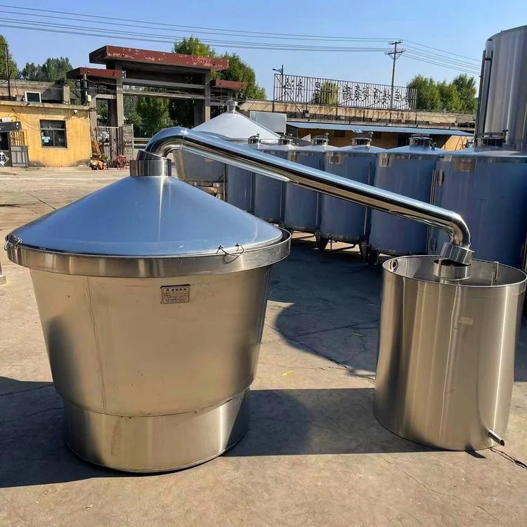 鞍山酿酒设备实景展示：不锈钢蒸锅正在工作，连接着冷却器，新酒从出酒管流出。_1