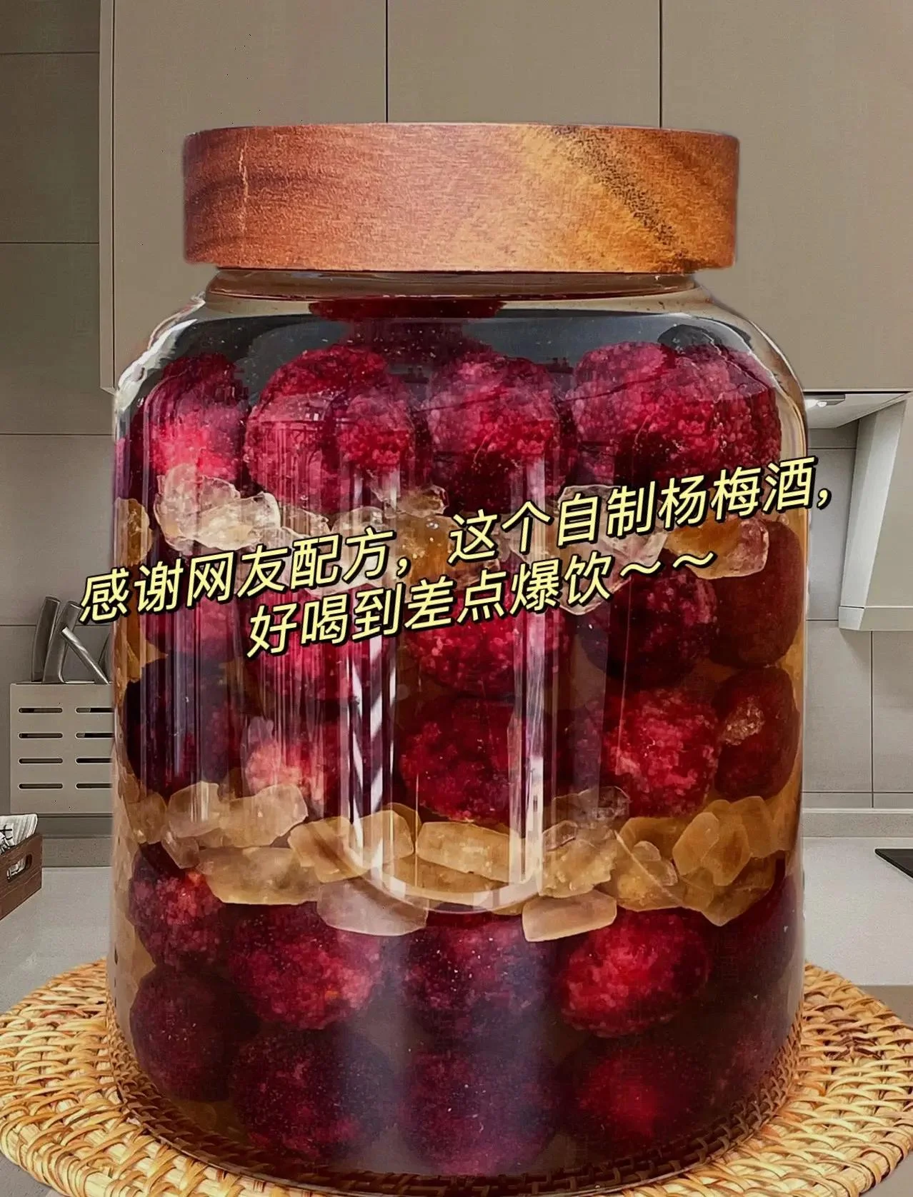 新鲜杨梅浸泡在透明玻璃罐的红色酒液中,阳光照耀下色泽诱人,展现家庭自制杨梅酒的温暖场景。_1
