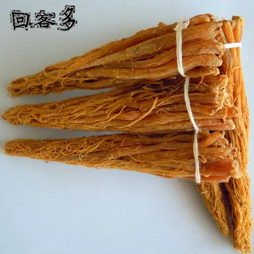 一罐正在浸泡中的红参须泡酒，酒液清澈呈琥珀色，红参须和枸杞清晰可见，展示传统家庭养生酒的制作状态。_1