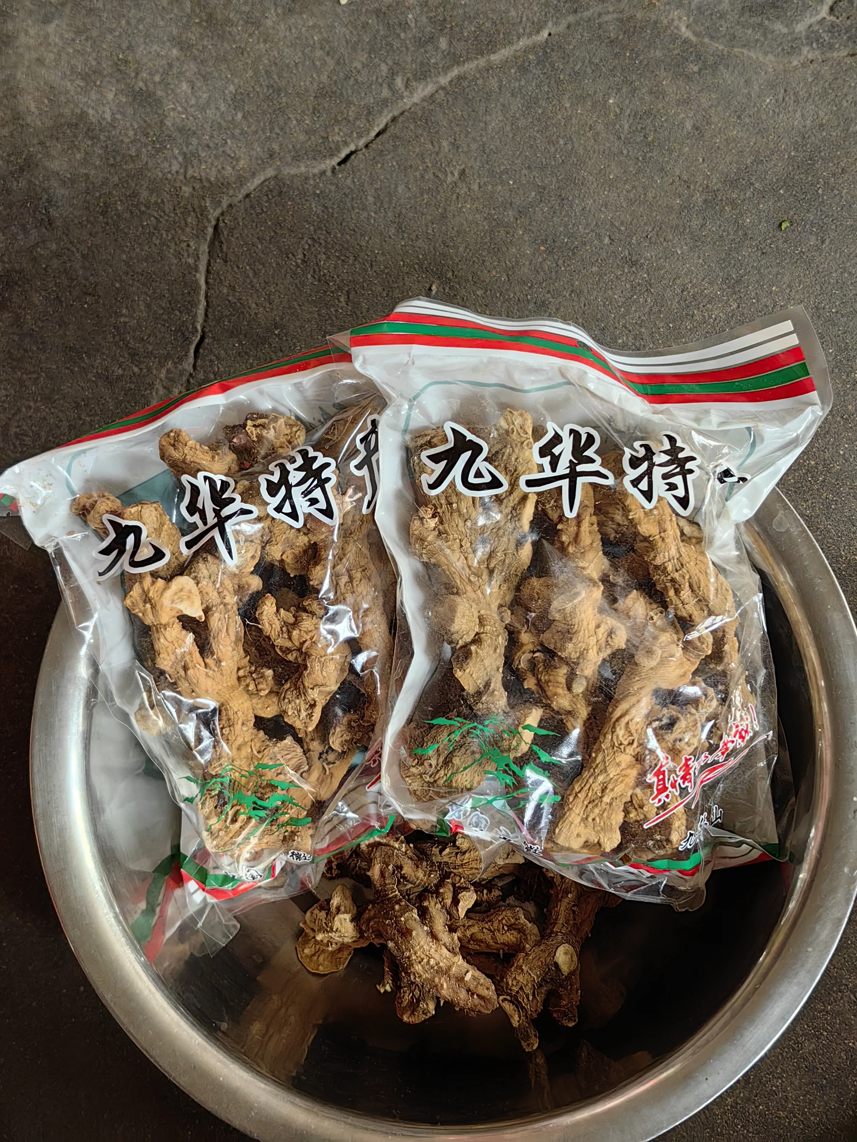 酿酒师在工作台上展示黄精与酒的泡制准备过程，玻璃瓶中可见黄精切片与清澈的酒液。_1