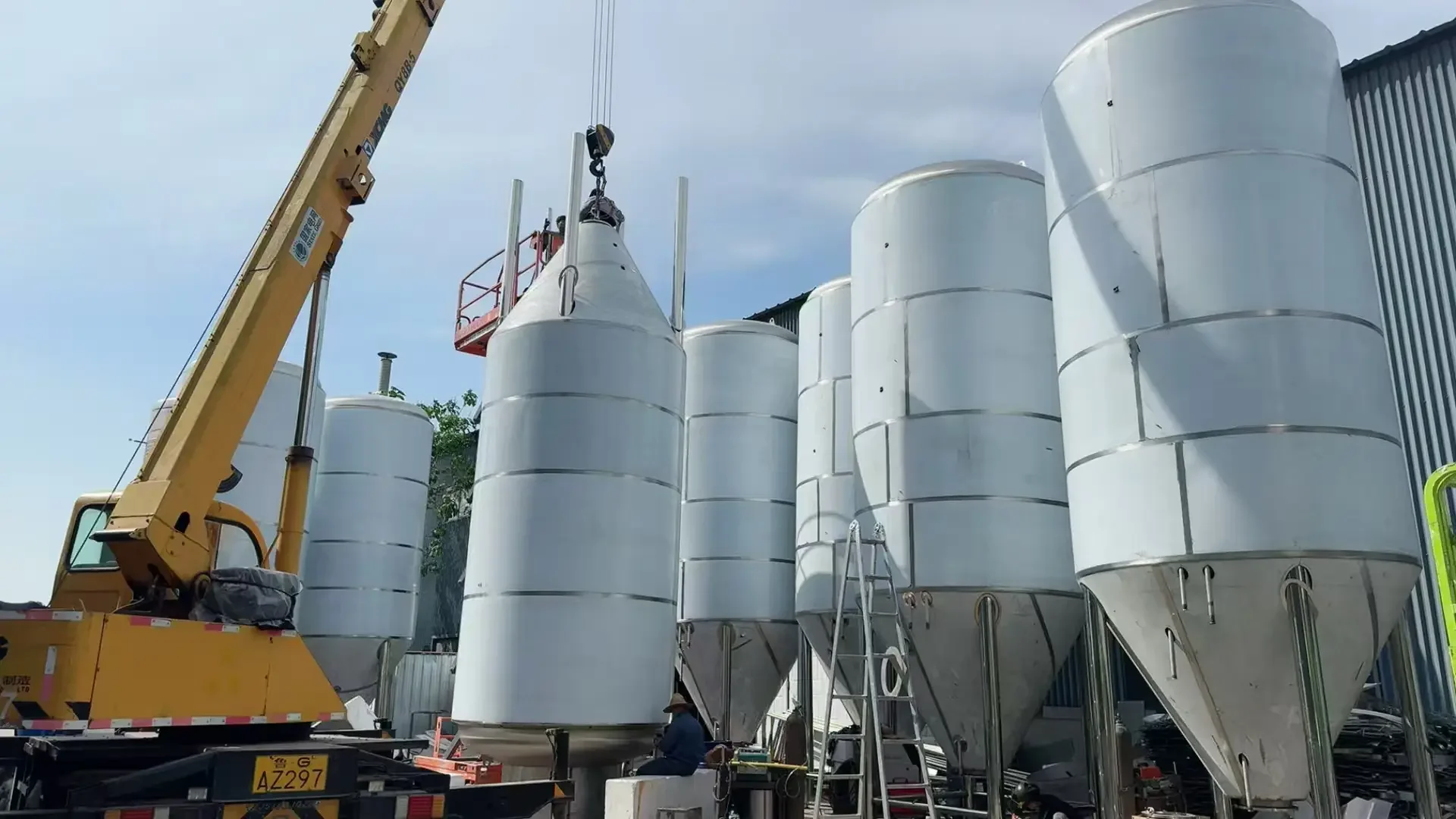 不锈钢白酒蒸馏设备在工厂车间内的特写，展示其精良的制造工艺和结构_1